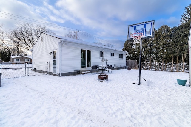 snow covered property with a fire pit and fence