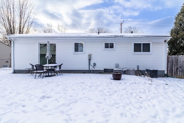 snow covered house with cooling unit and fence