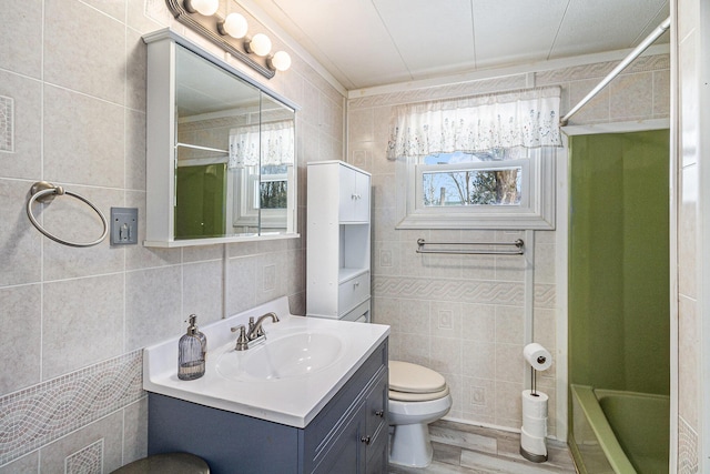 bathroom featuring tile walls, shower / bathing tub combination, toilet, vanity, and wood finished floors