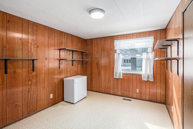 washroom featuring laundry area, visible vents, and wooden walls