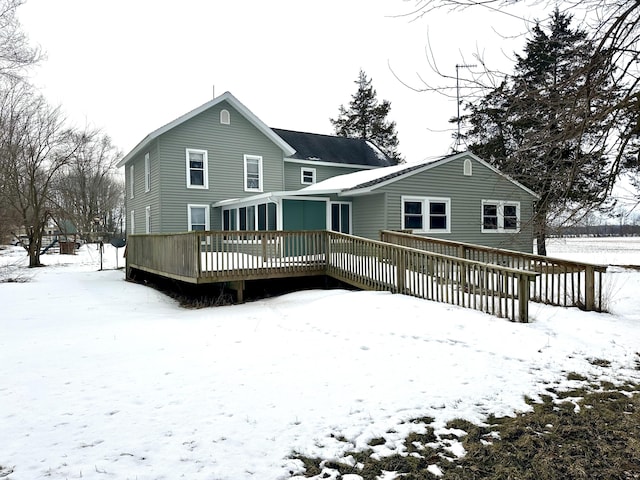 snow covered rear of property featuring a deck