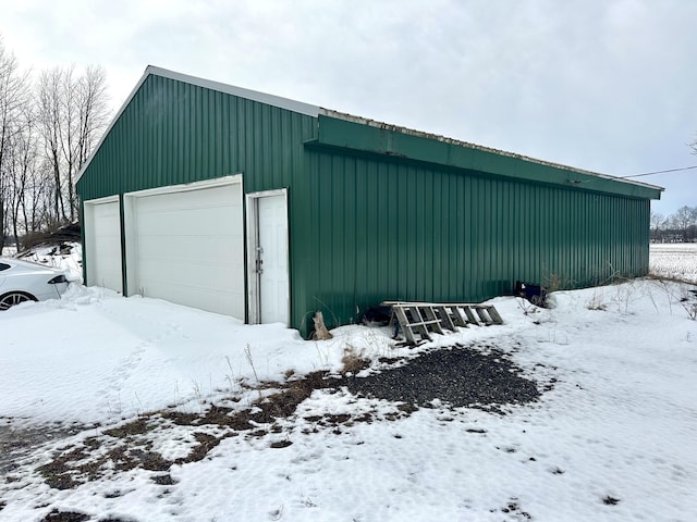 snow covered garage featuring a garage