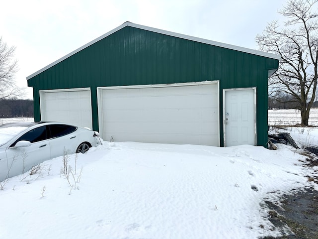 snow covered garage with a detached garage