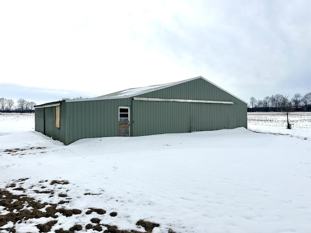 snow covered structure featuring a pole building and an outdoor structure