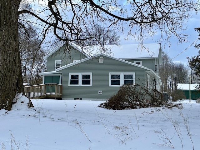 snow covered house featuring a deck