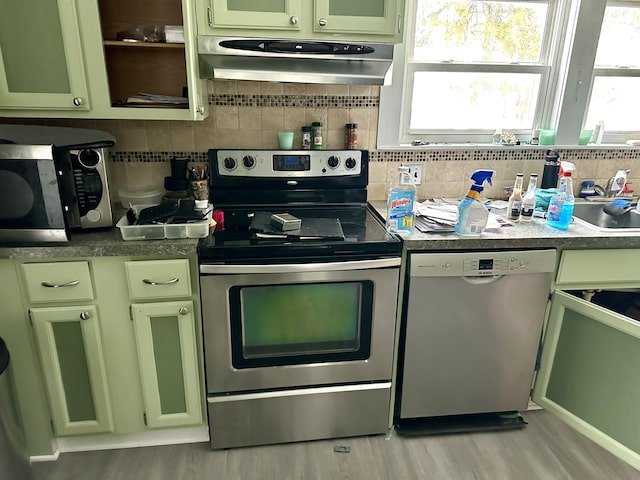 kitchen featuring stainless steel appliances, under cabinet range hood, and green cabinets