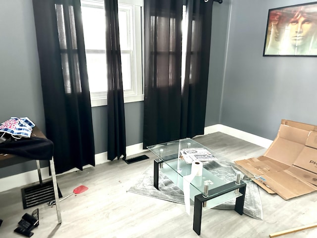 living area featuring plenty of natural light, baseboards, and wood finished floors