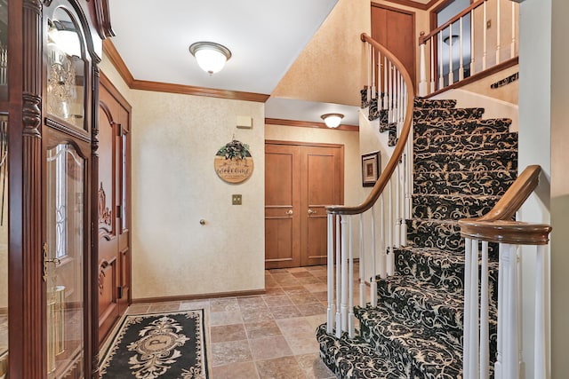 entrance foyer featuring baseboards and crown molding