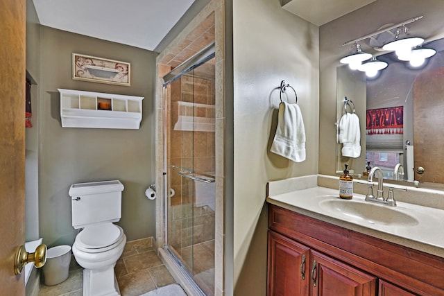 full bath with a stall shower, baseboards, vanity, and toilet