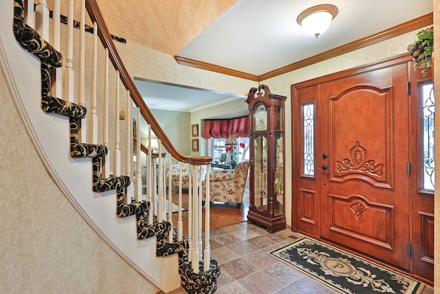 entryway featuring stone finish floor, crown molding, and stairway