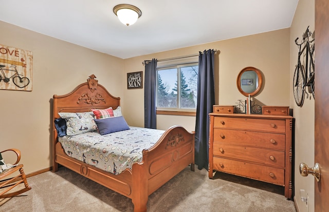 bedroom with baseboards and light colored carpet