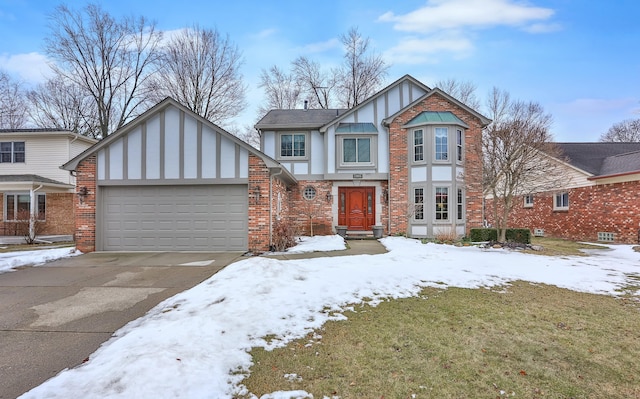 tudor home with a garage, brick siding, driveway, and stucco siding