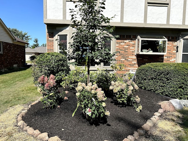 exterior space with brick siding and a lawn