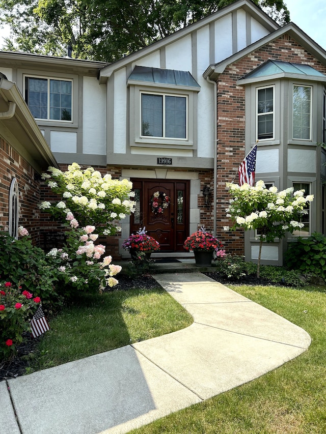 doorway to property with brick siding and stucco siding