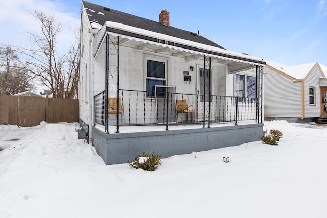 view of front facade featuring fence and a chimney