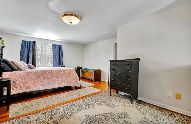 bedroom with baseboards and wood finished floors