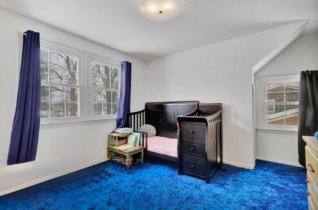 bedroom with dark colored carpet and baseboards