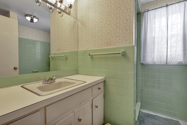 bathroom with a wainscoted wall, vanity, tile walls, and wallpapered walls