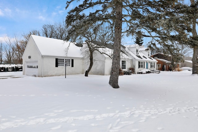 snow covered property featuring a garage