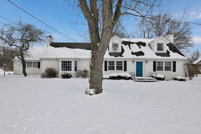 cape cod house featuring brick siding