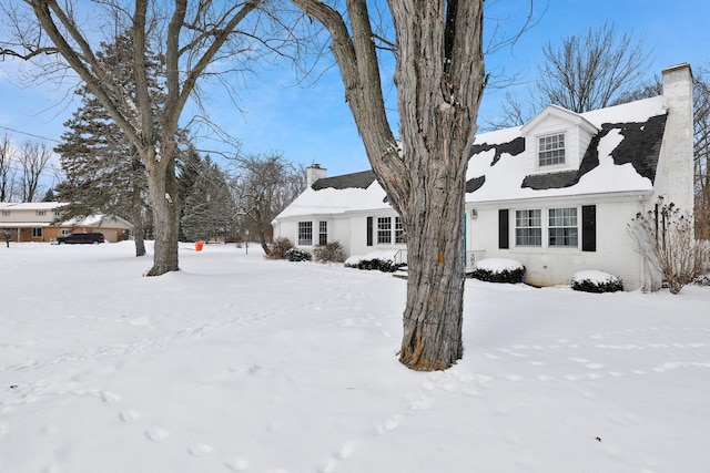 exterior space with brick siding and a chimney