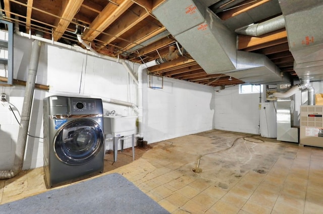 basement featuring gas water heater and washer / dryer