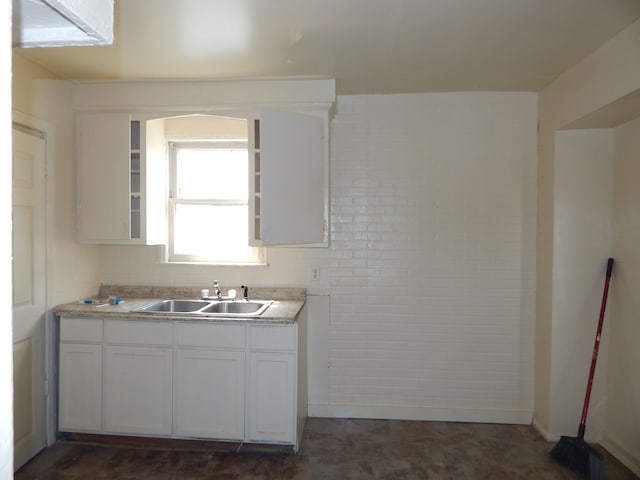 kitchen featuring light countertops, white cabinets, and a sink