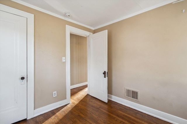 unfurnished bedroom featuring crown molding, dark wood finished floors, visible vents, and baseboards