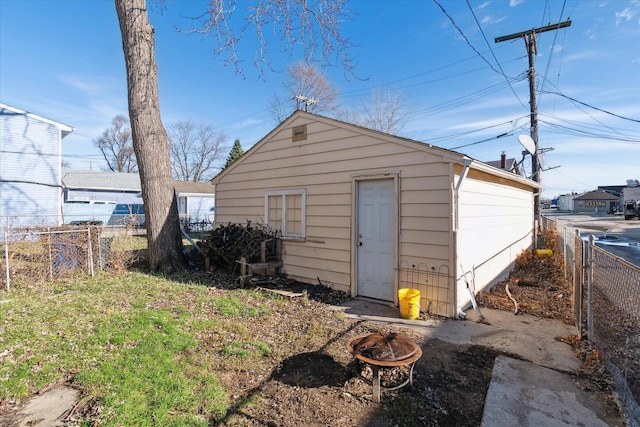 view of outdoor structure with fence and a fire pit