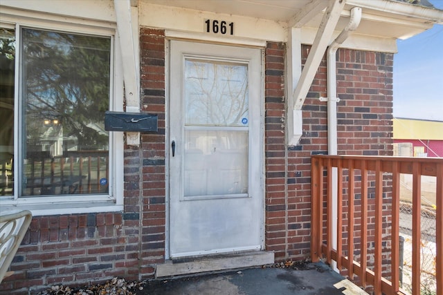 view of exterior entry featuring brick siding