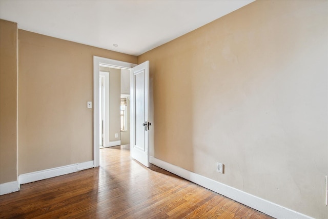 spare room with wood finished floors and baseboards