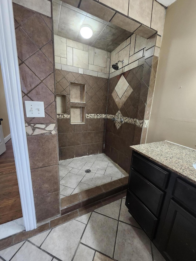 full bathroom with tiled shower and vanity