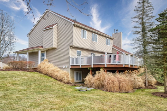 back of house featuring a deck, a lawn, and a chimney