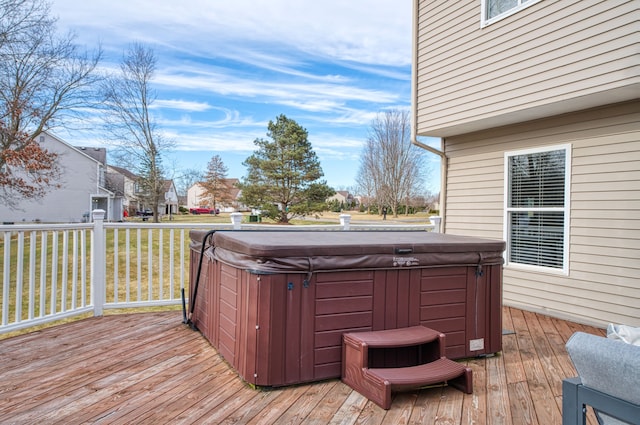 deck featuring a hot tub and a yard