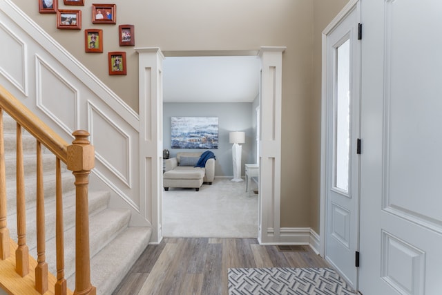 foyer featuring stairs, baseboards, and dark wood-type flooring