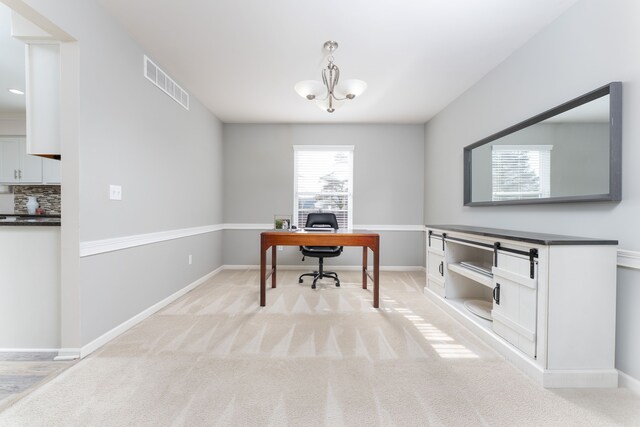 home office featuring light carpet, baseboards, visible vents, and a notable chandelier