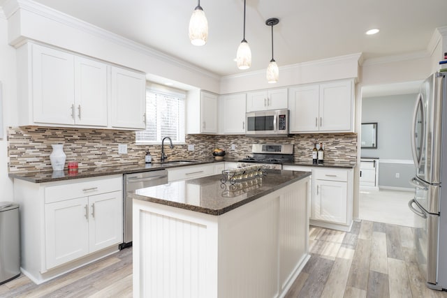 kitchen with a center island, stainless steel appliances, white cabinetry, a sink, and light wood-type flooring