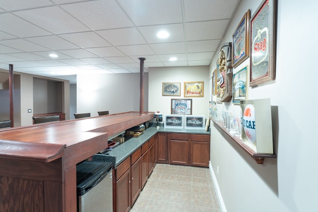 bar featuring recessed lighting, a drop ceiling, baseboards, and light tile patterned floors