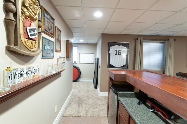 corridor featuring recessed lighting, a drop ceiling, light colored carpet, and baseboards