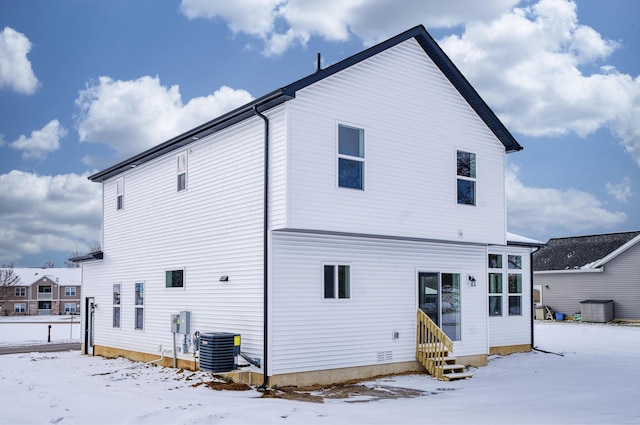 snow covered property featuring entry steps and central air condition unit