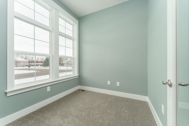 unfurnished room with baseboards and light colored carpet