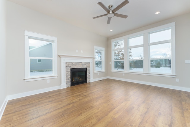 unfurnished living room featuring recessed lighting, a fireplace, light wood-style flooring, and baseboards