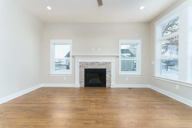 unfurnished living room with a healthy amount of sunlight, baseboards, and wood finished floors