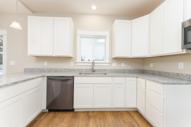 kitchen featuring light stone counters, stainless steel appliances, light wood-style flooring, white cabinetry, and a sink