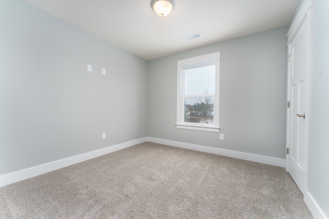 unfurnished room featuring baseboards, visible vents, and carpet flooring