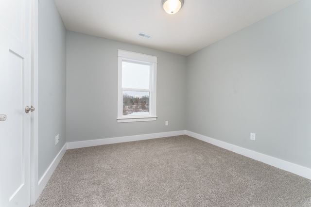 unfurnished room featuring carpet flooring, visible vents, and baseboards