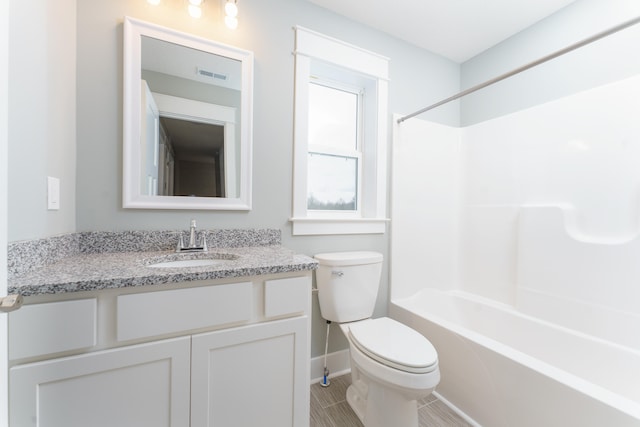 full bath with visible vents, toilet, washtub / shower combination, vanity, and baseboards