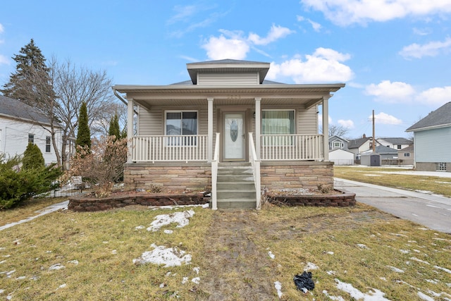 bungalow with a front yard and covered porch