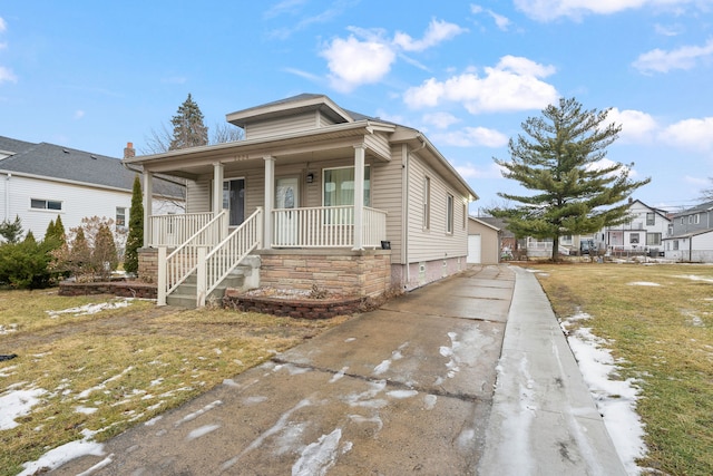 bungalow-style house featuring a garage, covered porch, and an outdoor structure