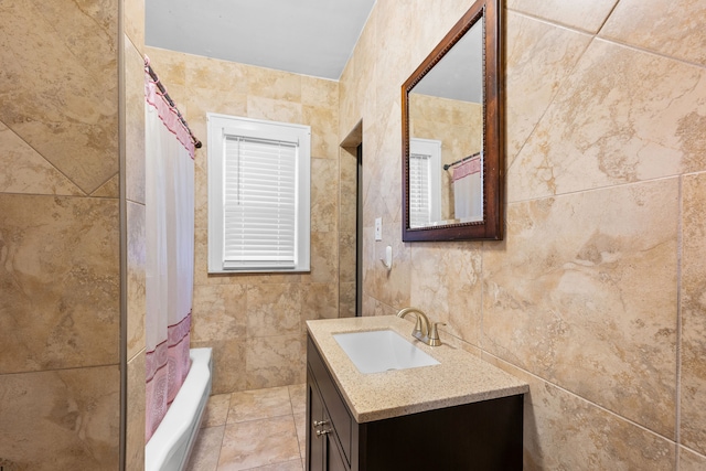 full bathroom with shower / bathtub combination with curtain, tile walls, and vanity